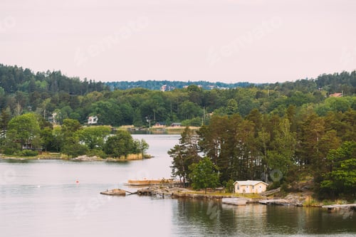 Preview: Sweden. Beautiful Swedish Wooden Log Cabins Houses On Rocky Island Coast In Summer Day. Lake Or