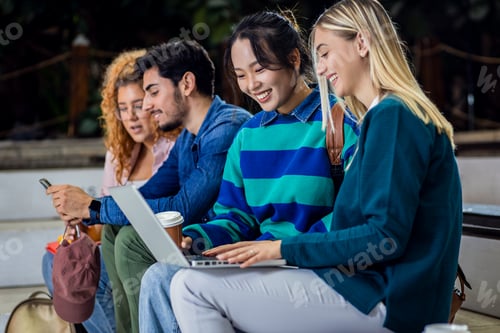 Preview: Diverse group of student siting in campus learning together.