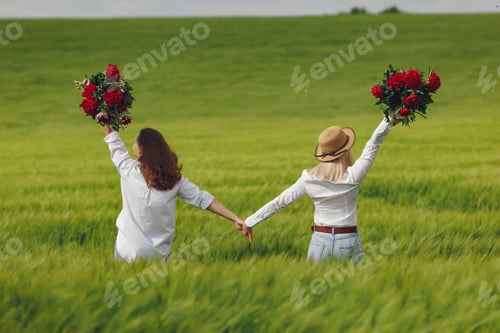 Preview: Women in elegant clothes standing in a summer field