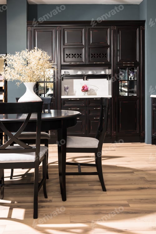 Preview: interior of modern dining room with black furniture, vase of dried flowers on table and wooden floor