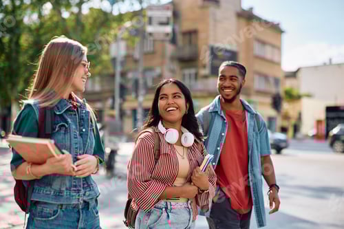 Preview: Happy Indian student talking to her university friends on the street.
