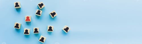 Preview: top view of wooden blocks with black and red human icons scattered on blue background, leadership
