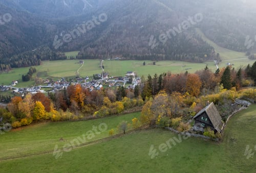 Preview: Autumn scenery embraces a charming village and secluded wooden cabin in the alps
