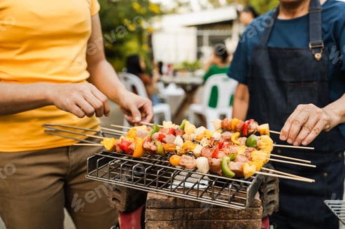 Preview: Skewers with colorful vegetables meat grilling, family friends gathering background, enjoying