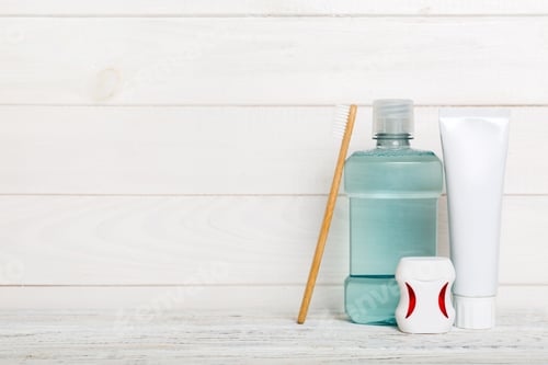 Preview: Mouthwash and other oral hygiene products on colored table top view with copy space. Flat lay.