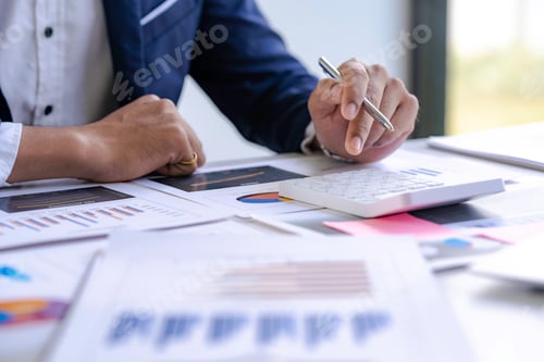 Preview: Asian male finance staff is calculating by using a calculator. Investment results to report to his b