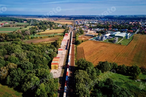 Preview: Aerial view of freight train with cargo containers near rural town