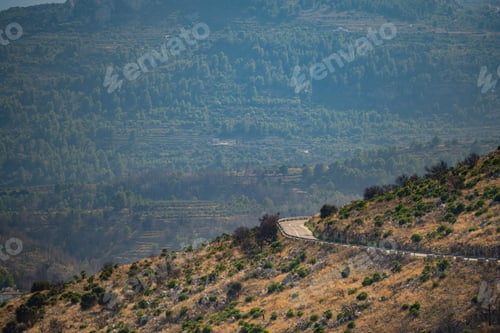 Preview: Curving road through serene mountainous landscape in Spain
