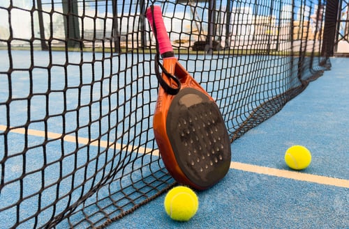 Preview: padel racket on a padel blue court with a ball