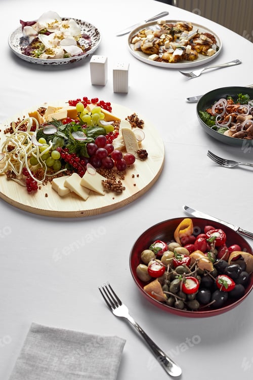Preview: Large festive table with different appetizers, assorted cheeses, salads, hot and cold appetizers on