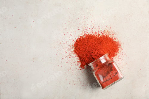 Preview: Glass jar with powdered red chili pepper and space for text on light background, top view