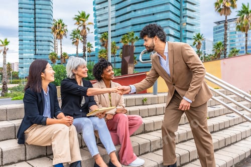 Preview: Businessman shaking hands with businesswoman in an outdoor meeting