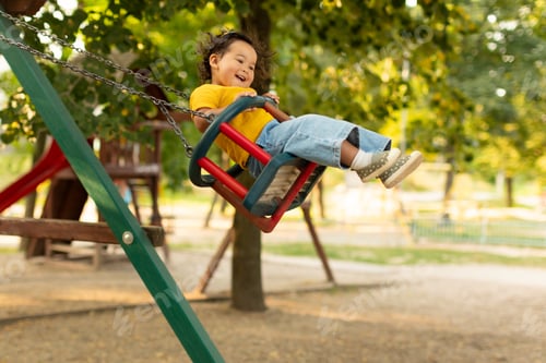 Preview: Joyful Japanese Baby Girl Swinging On Swings At Outdoor Playground