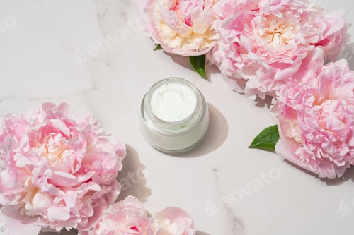 Preview: Professional product shot of open cream jar with peony accent, highlighting formula texture