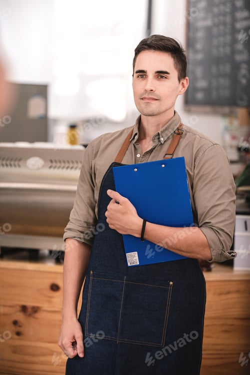 Preview: Male barista working at a coffee shop ready to order