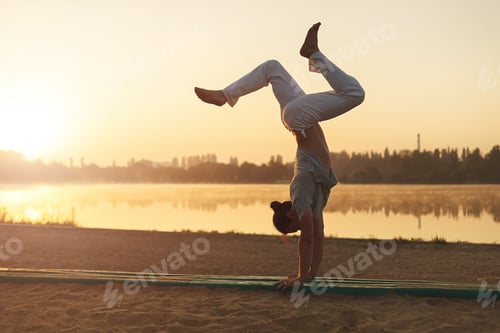 Preview: Athletic yoga man workout training on the beach sunrise