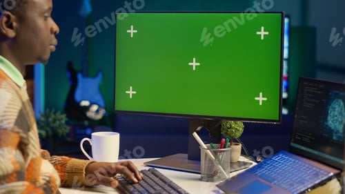 Preview: Black person programming neural network code with a green screen