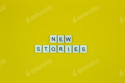 Preview: New stories- scrabble letters word on a yellow background