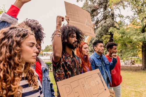 Preview: Activists protesting for peace and human rights raising fists and holding signs in a park