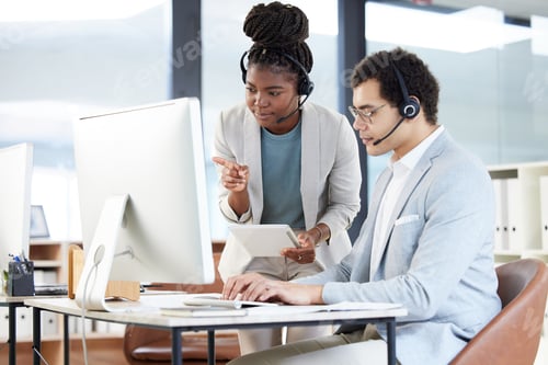 Preview: Shot of two call centre agents working together in an office