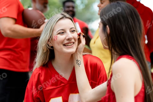 Preview: Woman getting her cheeks painted with her team colors