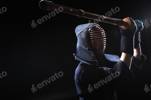 Preview: Kendo fighter in armor practicing with bamboo sword on black