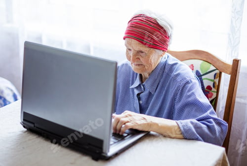 Preview: Senior woman using laptop computer at home