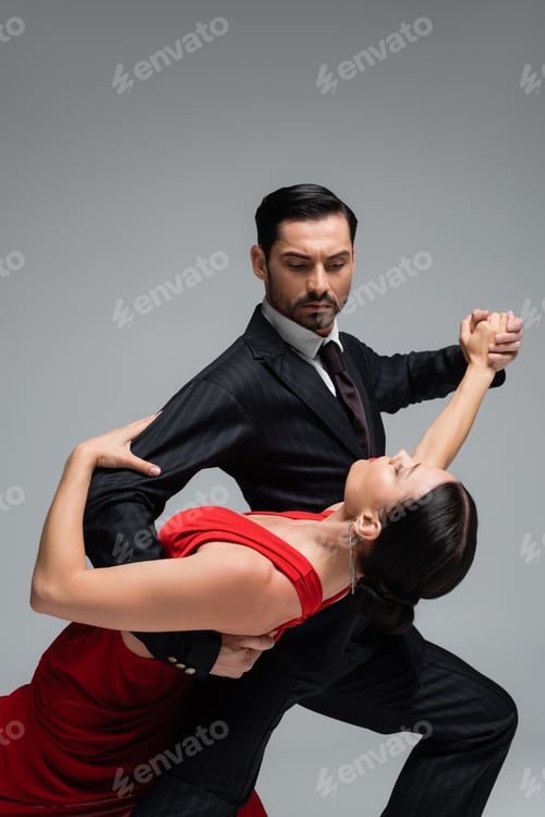 Preview: Man in suit dancing tango with brunette partner isolated on grey