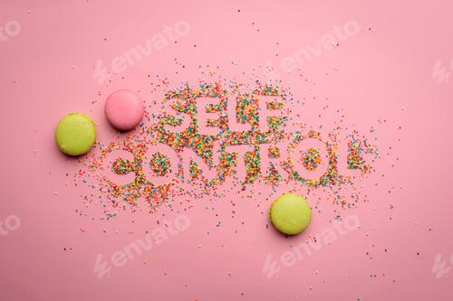 Preview: Top view of self control lettering made from candies isolated on pink, healthy living concept