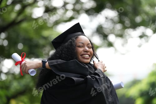 Preview: Two graduates in gowns share a warm embrace
