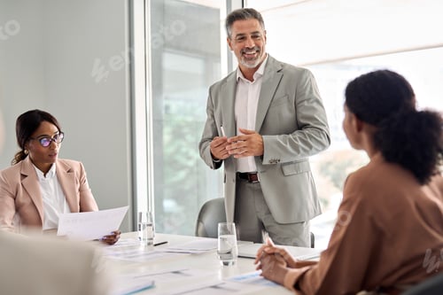 Preview: Busy older leader and company employees at business meeting discussing work.