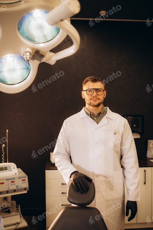 Preview: Portrait of man surgeon in glasses looking at camera with serious expression. Handsome doctor