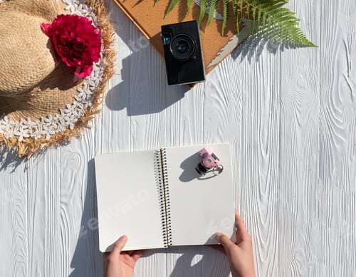 Preview: Traveler's hands hold a blank notebook to keep track of summer travel plans