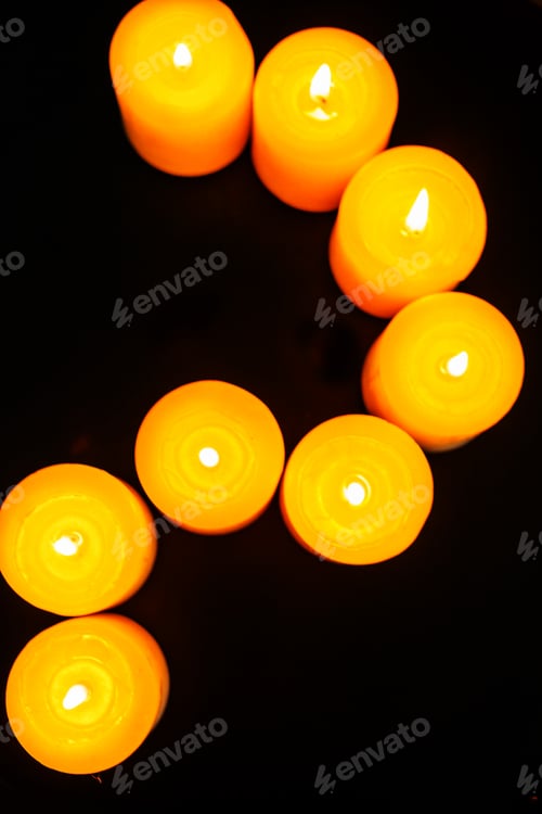 Preview: closeup to burning candles in darkness