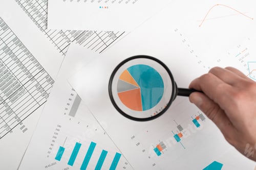 Preview: Finance analytics, research of economic indicators concept. Close-up of hand holding magnifying