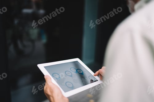 Preview: Cropped male using modern touch pad with 4g internet connecting for editing media content