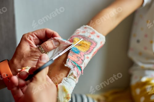 Preview: Father removing a plaster cast teen girl with a broken arm
