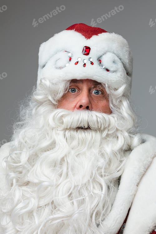 Preview: Xmas and new year studio portrait of gray-haired beared surprised male on gray studio background
