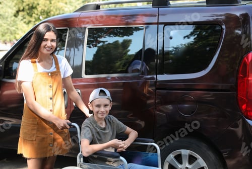 Preview: Young woman with boy in wheelchair near van outdoors