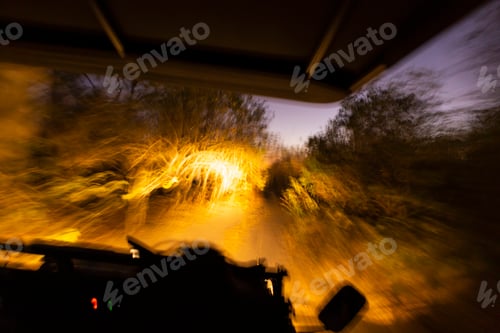 Preview: Vehicle with lights moving along a road after sunset.