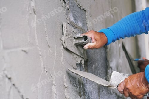 Preview: hand of worker plastering cement on wall