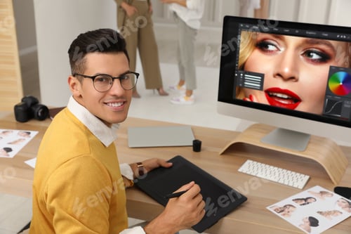 Preview: Professional retoucher working with graphic tablet at desk in photo studio