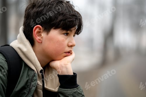 Preview: A teenager is sitting in the park on a bench