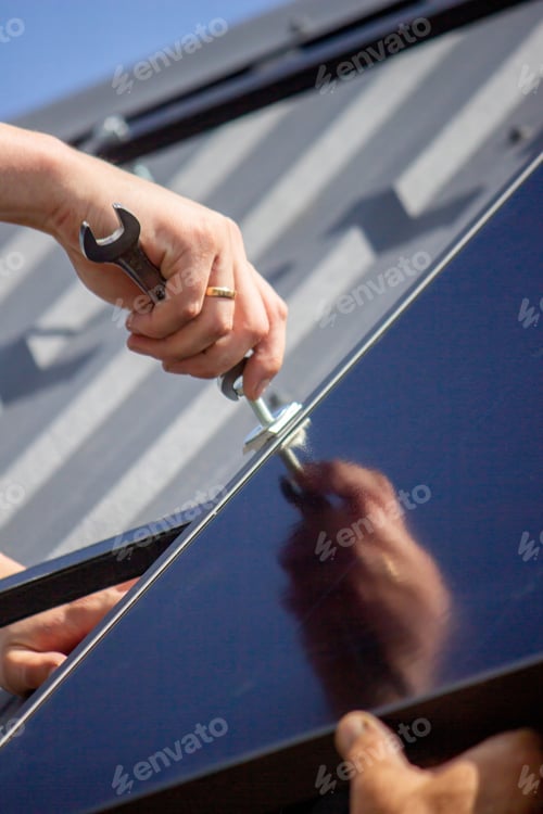 Preview: A man is installing solar panels on a roof. Selective focus
