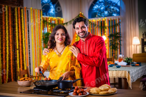 Preview: Indian young husband surprises wife with gift while cooking food on diwali festival eve in kitchen