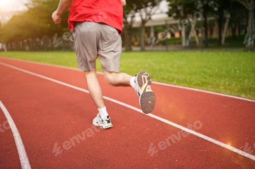 Preview: Rear view of a man running in a track