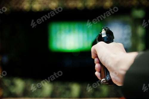 Preview: Hand of man with gun aim at shooting range.