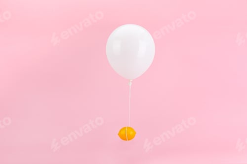 Preview: Fresh lemon tied to a white balloon on a pink background