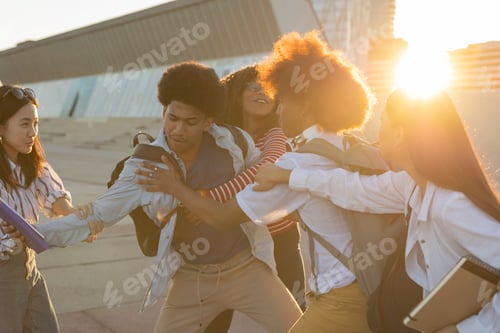 Preview: Young Friends Playfully Interacting Outdoors at Sunset