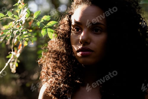Preview: relaxed afro american woman in forest at sunset. Lifestyle. Nature